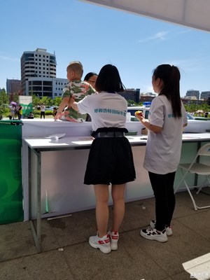 呼市車展志愿者幫忙扶住孩子